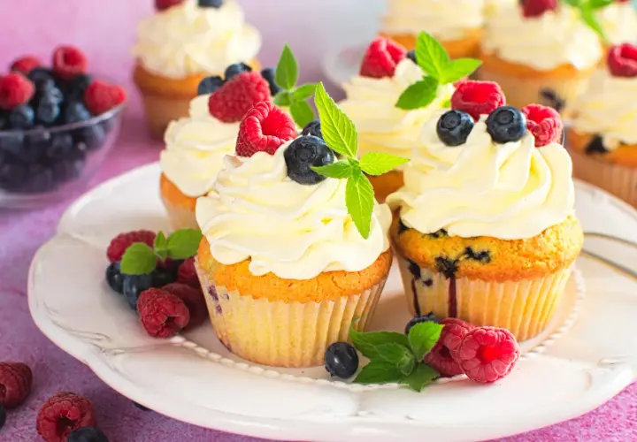 Pyszne babeczki z mascarpone, udekorowane malinami, borówkami i miętą. Idealne na deser!