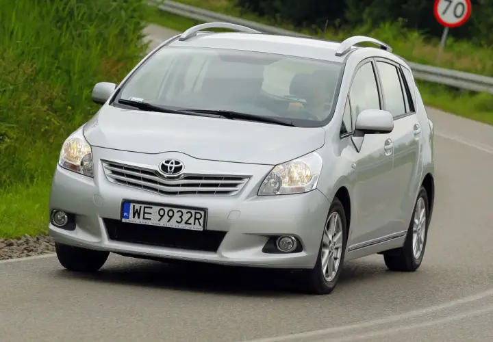 Srebrny Toyota Verso S jedzie po drodze, za kierownicą siedzi osoba.