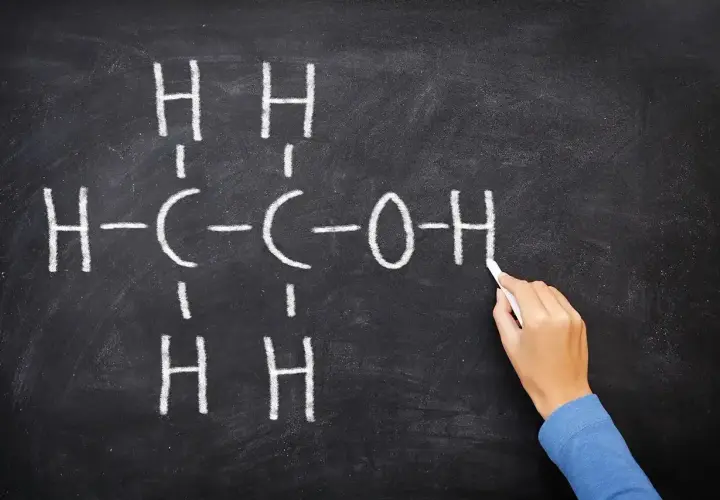 Rysunek na tablicy przedstawia wzór etanolu, kluczowego związku w chemii alkoholi.