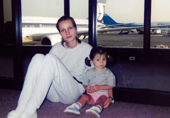 Agnieszka Kotlarska z córką na lotnisku, w tle samoloty British Airways i El Al.