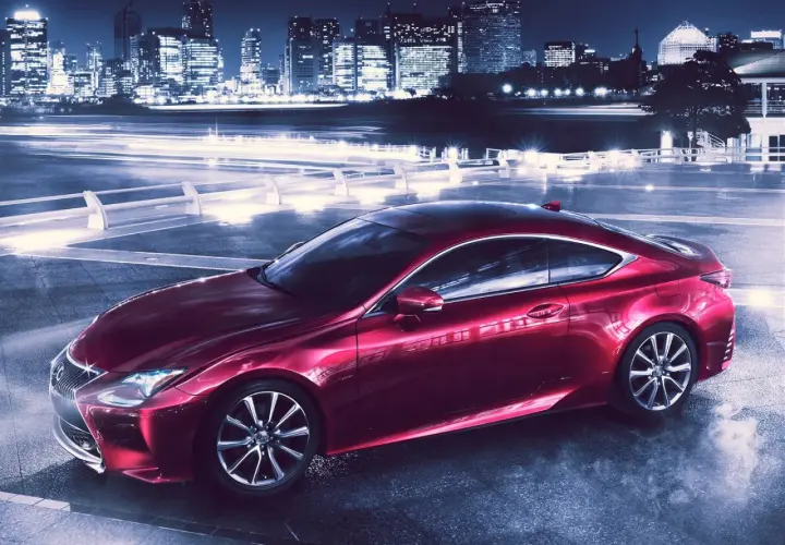 Czerwony Lexus RC 350 na tle nocnego miasta z rozmazanymi światłami.
