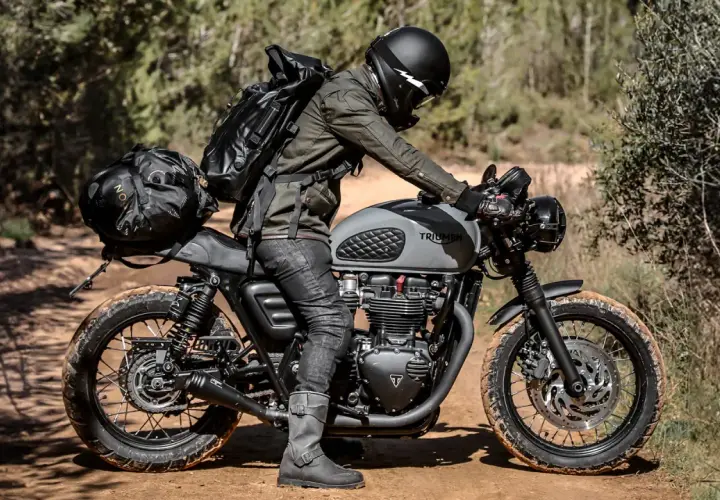 Motociclista con zaino e borse moto custom, pronto per un'avventura su sterrato.