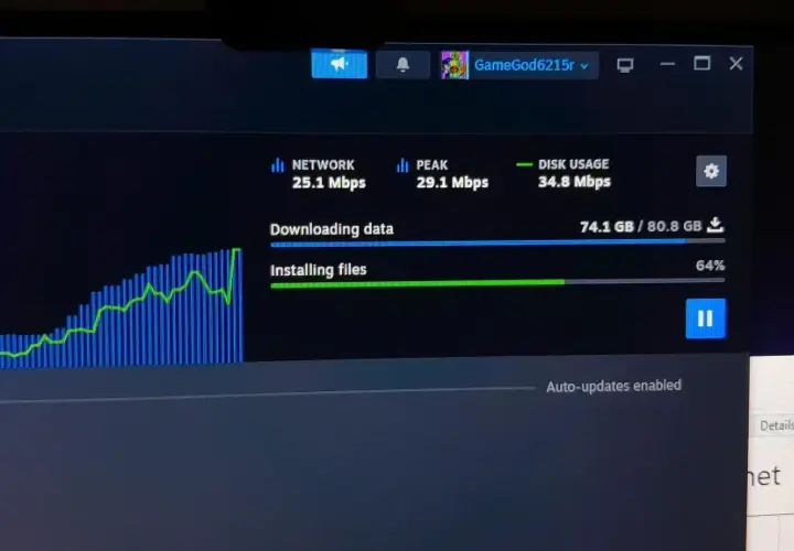 Monitorowanie pobierania na Steam, aby sprawdzić, jak przyśpieszyć pobieranie. Widoczny wykres sieci i postęp instalacji.