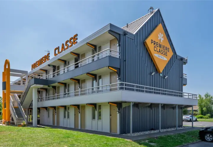 Façade d'un hôtel Première Classe avec escalier extérieur et parking.