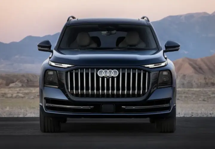 L'imponente Audi Q9 si staglia su uno sfondo desertico, con la sua griglia audace e i fari affilati che catturano lo sguardo.