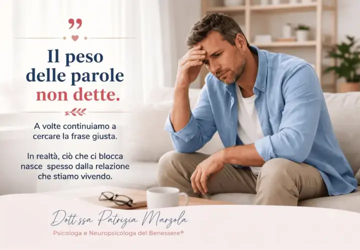 Uomo pensieroso seduto su un divano, con la frase "Il peso delle parole non dette". A volte il "ti desidero significato" si nasconde nel silenzio delle relazioni.