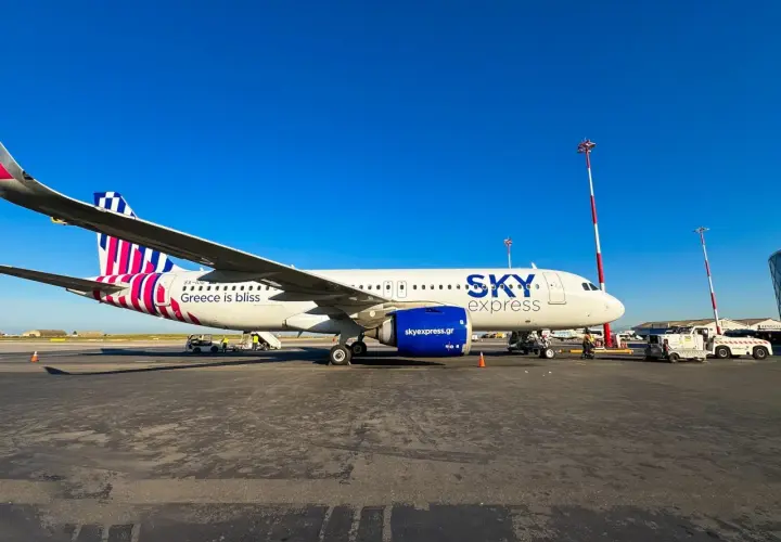 Samolot greckich linii lotniczych Sky Express na płycie lotniska. Napis "Greece is bliss" zapowiada podróż.