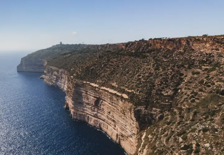 Malta: klify nad turkusowym morzem, skaliste wybrzeże z roślinnością.
