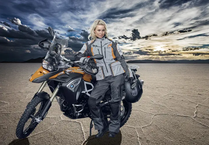 Donna in abbigliamento tecnico da moto, pronta per un'avventura. Ecco come vestirsi per andare in moto donna, con giacca e pantaloni protettivi.