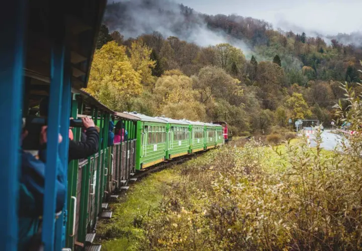 Zielony pociąg turystyczny mknie przez jesienne Bieszczady, zabierając pasażerów z Krakowa na malowniczą podróż.