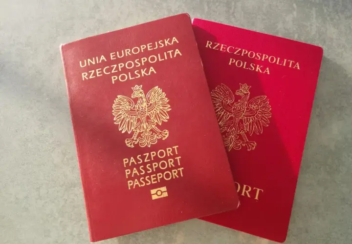 Dwa polskie paszporty w kolorze czerwonym leżą obok siebie.