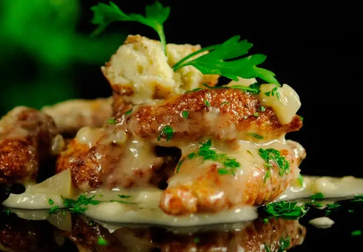 Deliciosas albóndigas de rape doradas, cubiertas con una cremosa salsa y perejil fresco. Un plato que invita a probar.