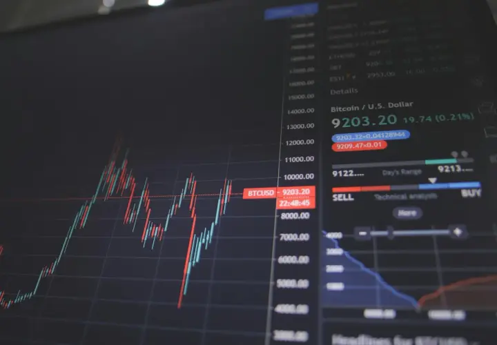 Wykres świecowy pokazuje kurs bumech Bitcoina (BTCUSD) na poziomie 9203.20. Widać też dane o dziennym zakresie i przyciski "SELL" i "BUY".