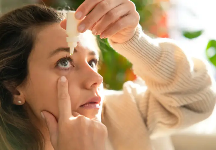 Donna applica collirio per alleviare i sintomi della congiuntivite allergica, cercando sollievo rapido.