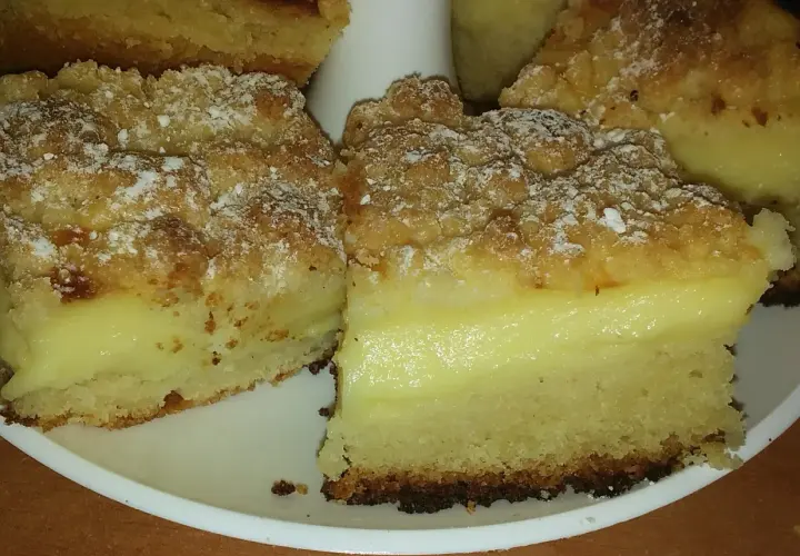 Pyszne ciasto drożdżowe z budyniem, posypane cukrem pudrem. Idealne na deser!