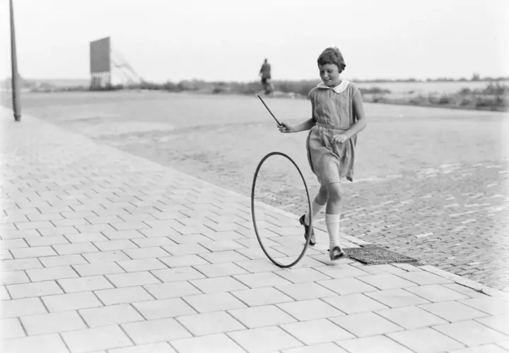 Bambina gioca con un cerchio, un gioco che ricorda i giochi antichi siciliani.