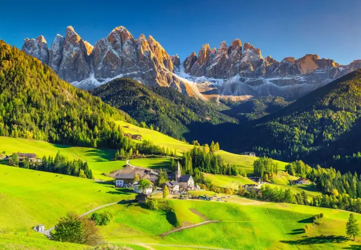 Un village pittoresque dans les Dolomites en Italie, idéal pour le camping. Des montagnes majestueuses, des prairies verdoyantes et des chalets traditionnels.