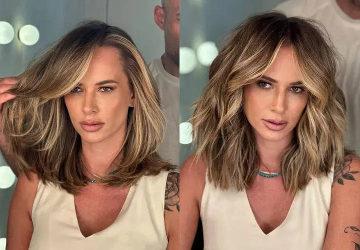 Kobieta z burzą blond włosów, które stylista układa, pokazując, jak zmniejszyć objętość włosów.