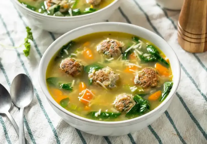 Pyszna zupa klopsowa babci z klopsikami, makaronem nitki, marchewką i szpinakiem w aromatycznym bulionie.