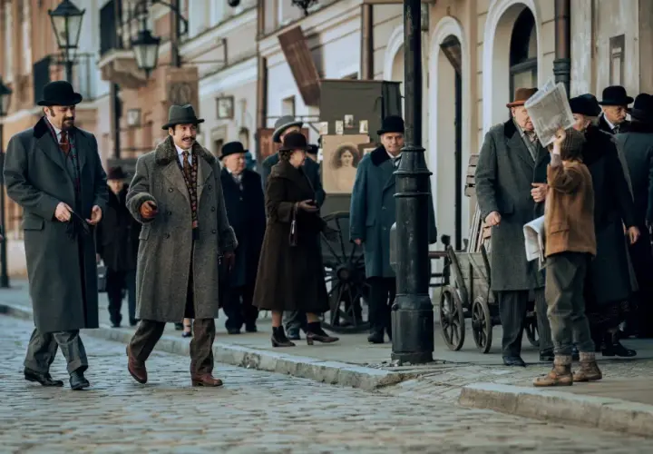 Ulica w stylu retro, gdzie kręcono film Znachor. Ludzie w płaszczach i kapeluszach spacerują po bruku.