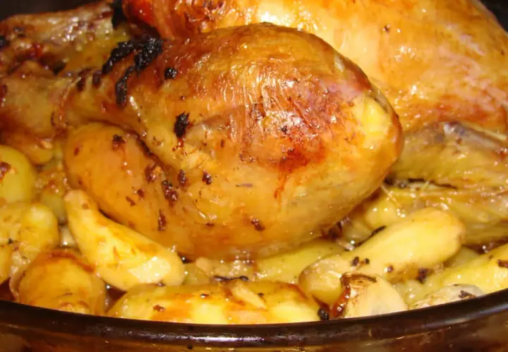 Un plat de poulet au four avec des pommes de terre dorées et juteuses, prêt à être dégusté.