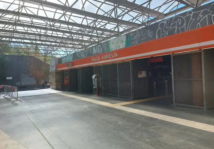 Ingresso della stazione **Valle Aurelia** a Roma, con tettoia metallica e graffiti.