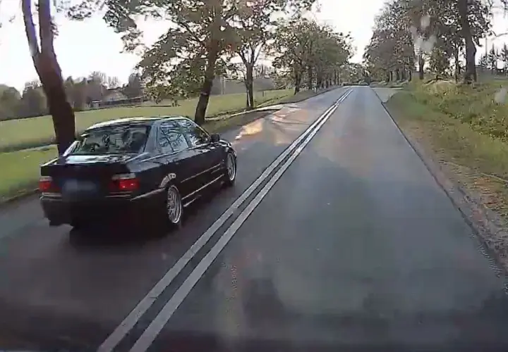 Czarny sedan jedzie po drodze z podwójną ciągłą. Czy można wyprzedzać na podwójnej ciągłej? To pytanie zadaje sobie wielu kierowców.