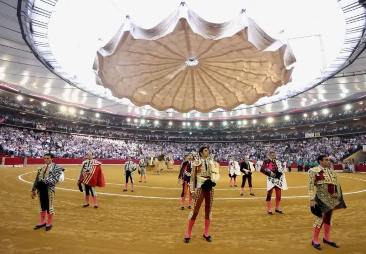 Toreros listos en una de las plazas de toros cubiertas en España, con público en las gradas y un techo desplegable.