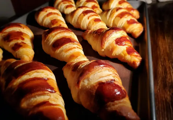 Une fournée de croissants dorés, parfaits pour une recette facile. Ils sont brillants et appétissants.