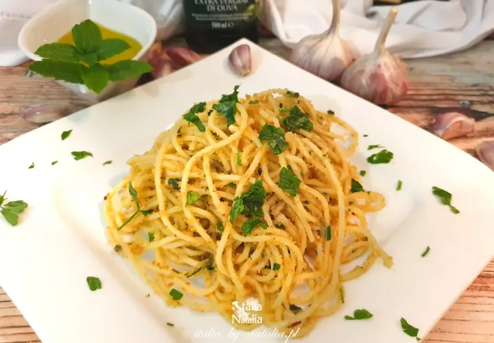 Pyszne spaghetti aglio e olio, posypane natką pietruszki, z czosnkiem i oliwą w tle.