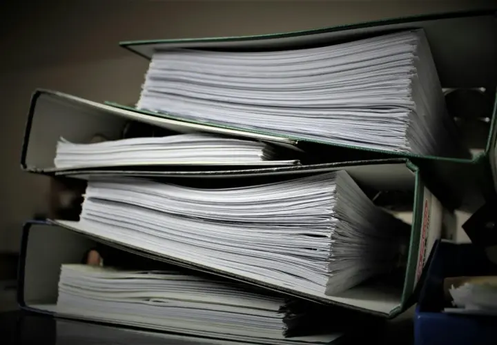 Stosy dokumentów w segregatorach. Szukasz informacji, jak znaleźć numer księgi wieczystej?