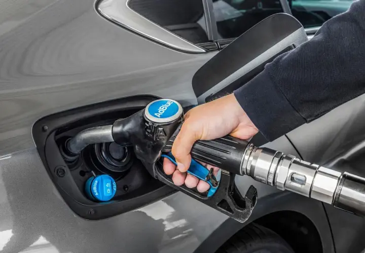 Persona repostando AdBlue en su coche. La cantidad de kilómetros que dura el AdBlue varía según el vehículo y el estilo de conducción.