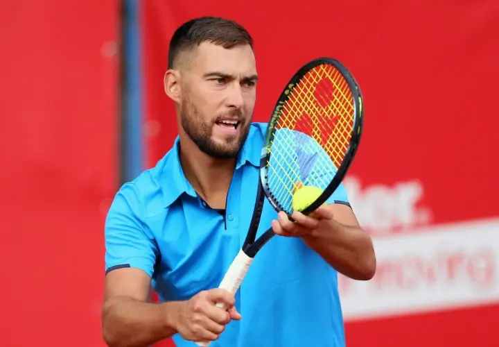 Jerzy Janowicz, z rakietą i piłką, może symbolizować koniec kariery.