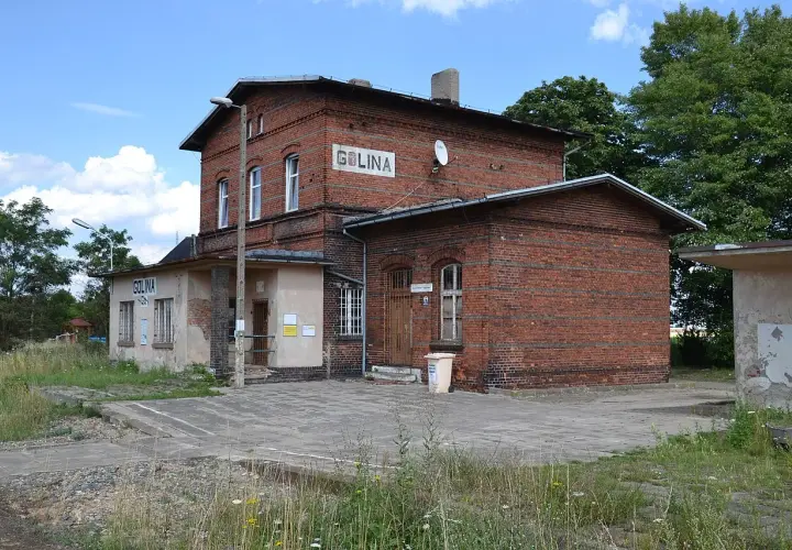 Stary ceglany budynek dworca kolejowego Golina z napisem "GOLINA" na fasadzie.