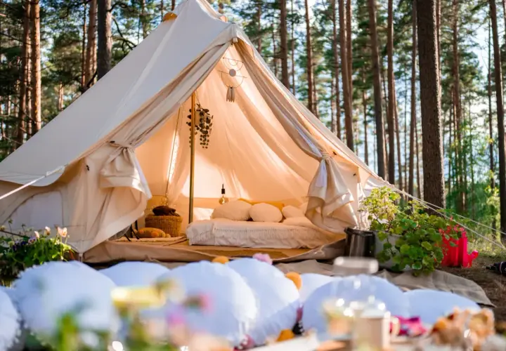 Przytulny namiot w lesie, idealny na glamping noclegi. Wygodne łóżko, dekoracje i atmosfera relaksu.