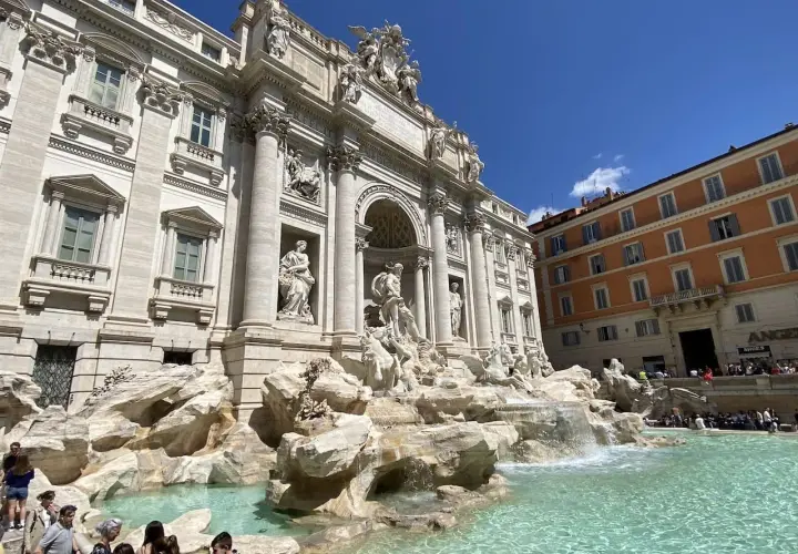 Fontaine de Trevi, un chef-d'œuvre baroque à Rome, Italie, avec des touristes admirant sa splendeur sous un ciel bleu.