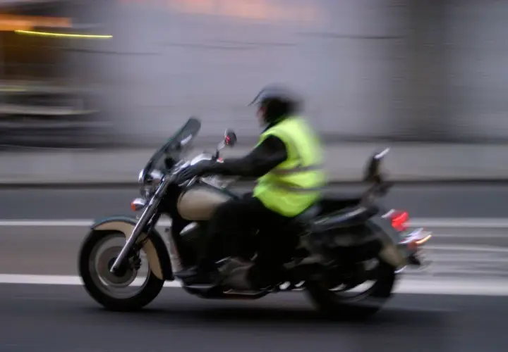 Motociclista con chaleco reflectante, esencial para la seguridad. Es obligatorio llevar chaleco reflectante en la moto.