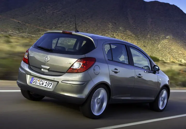 Szary Opel Corsa D 1.2 na drodze, z widocznym rozmiarem opon.