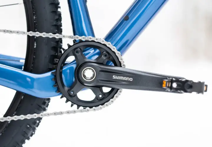 Widok na korbę Shimano i łańcuch roweru. Dowiedz się, jak odkręcić pedały w rowerze, by wymienić je na nowe.