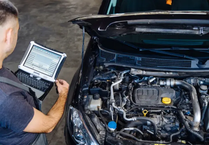Mechanik diagnozuje przedmuchy w silniku za pomocą komputera.