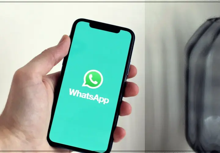 Dłoń trzyma smartfon z logo WhatsApp. Dowiedz się, jak dzwonić bez karty SIM, korzystając z tej popularnej aplikacji.