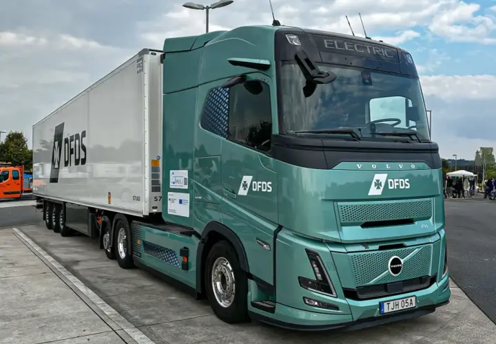 Zielony, elektryczny Volvo FH z naczepą DFDS. Zastanawiasz się, ile ton ma tir? Ten model jest gotowy na wyzwania.