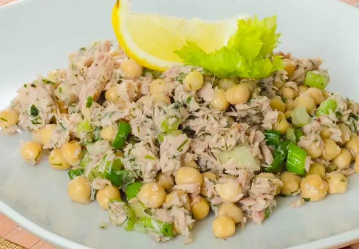 Insalata di ceci e tonno, fresca e saporita, guarnita con limone e sedano.