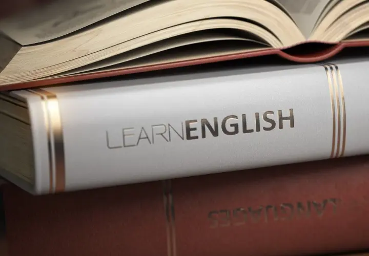 Stos książek, na wierzchu otwarta, z napisem "LEARN ENGLISH" na białej okładce. Idealne książki po angielsku do nauki.