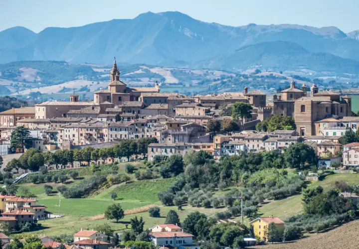 Panoramica di Corinaldo, borgo medievale nelle Marche, con le sue case in pietra e le colline verdi circostanti.