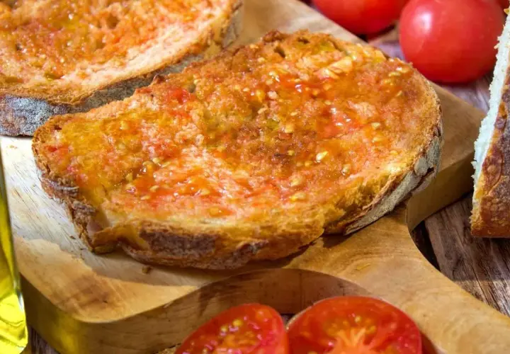 Rebanadas de pan tostado con tomate rallado y aceite de oliva, un delicioso pan de tomate listo para disfrutar.