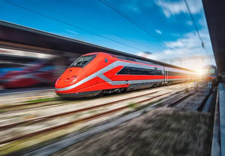 Un train rouge vif file sur les rails, prêt à emmener ses passagers de Rome à Florence.