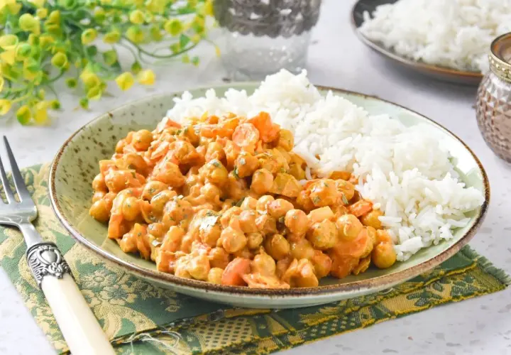 Plato de arroz al curry con garbanzos y zanahoria, servido con arroz blanco esponjoso.