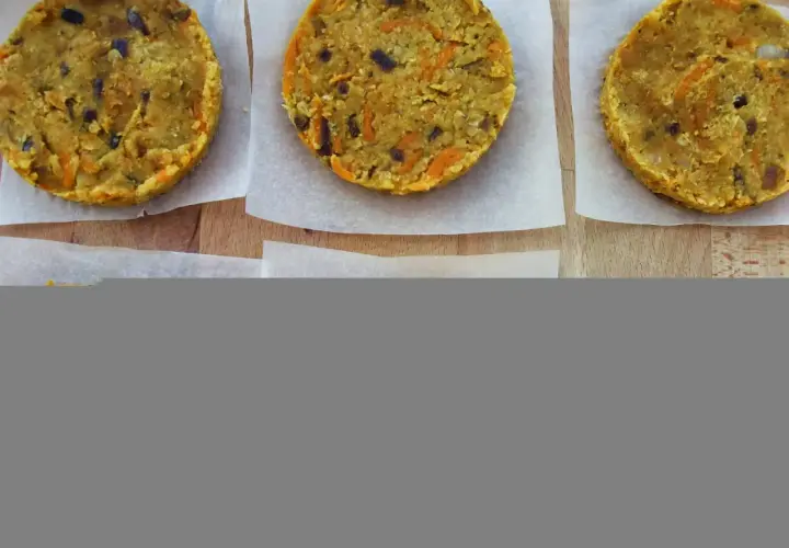 Seis hamburguesas de lentejas caseras, listas para cocinar. Tienen trocitos de zanahoria y cebolla morada.