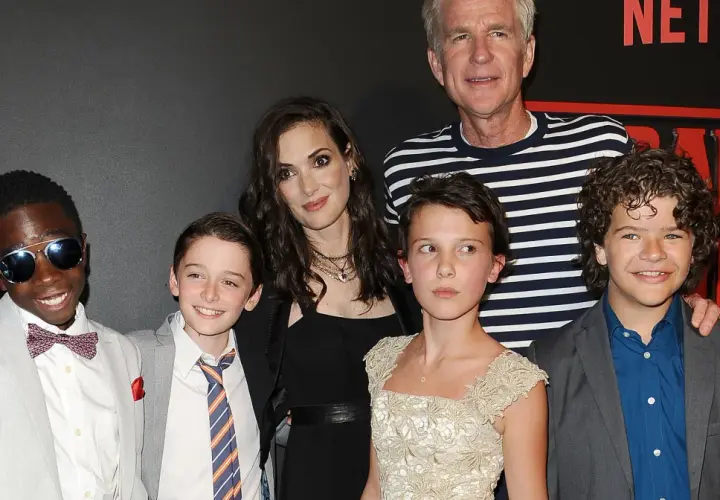 Aktorzy z "Stranger Things" pozują do zdjęcia. Millie Bobby Brown, która gra Eleven, wygląda na około 16 lat, co sugeruje, że w 4. sezonie mogła mieć podobny wiek.